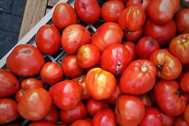 A photo of a pile of red tomatoes.