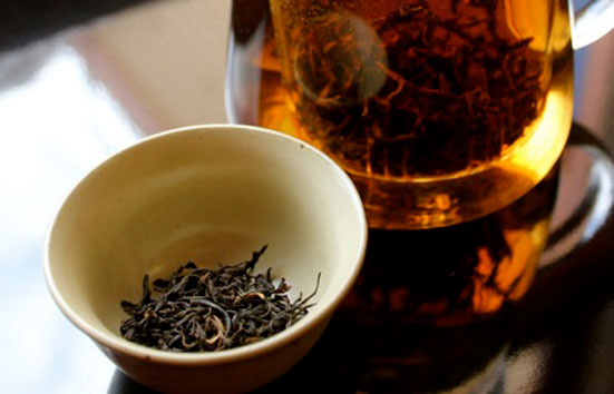 Zingerman's Tea Steeping Next To A Cup Of Leaves