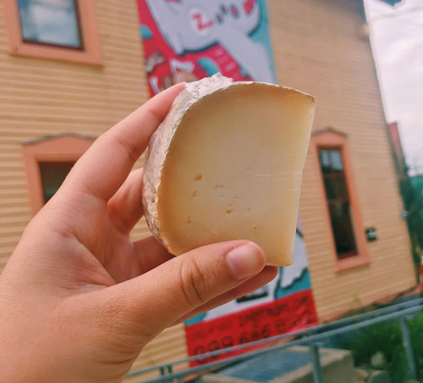 Pascualino Cheese being held up outside of Zingerman's Deli