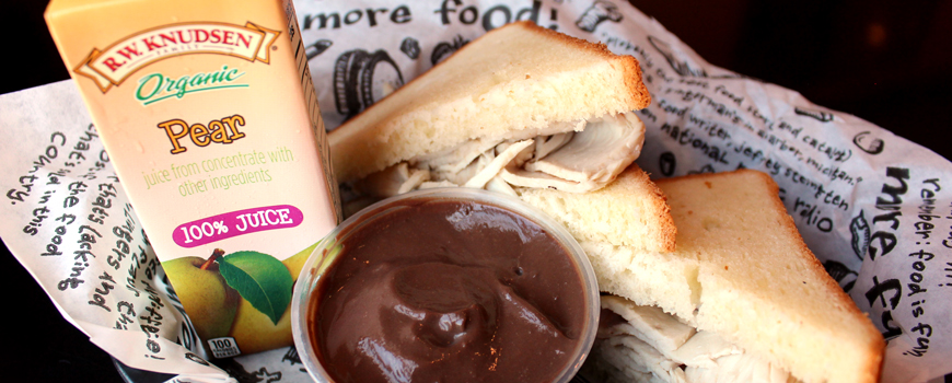 Zingerman's Deli Kid's Meal Deal with a turkey sandwich, pear juice and chocolate pudding in a sandwich basket