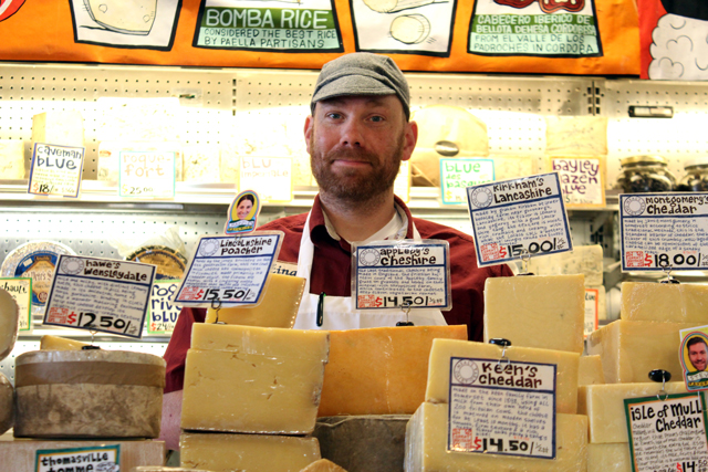 Zingerman's Deli Cheesemonger behind a mountain of cheese in the retail cheese area, how to build cheeseboard