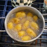 Syracuse Salt Potatoes to Make at Home A photo of a pot of potatoes in water boiling on the stove.