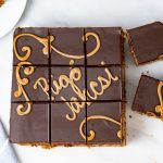 Rigó Jancsi Chocolate Rum Torta from the Bakehouse A top-down photo of a Rigo Jancsi slices into even squares on a marble surface.
