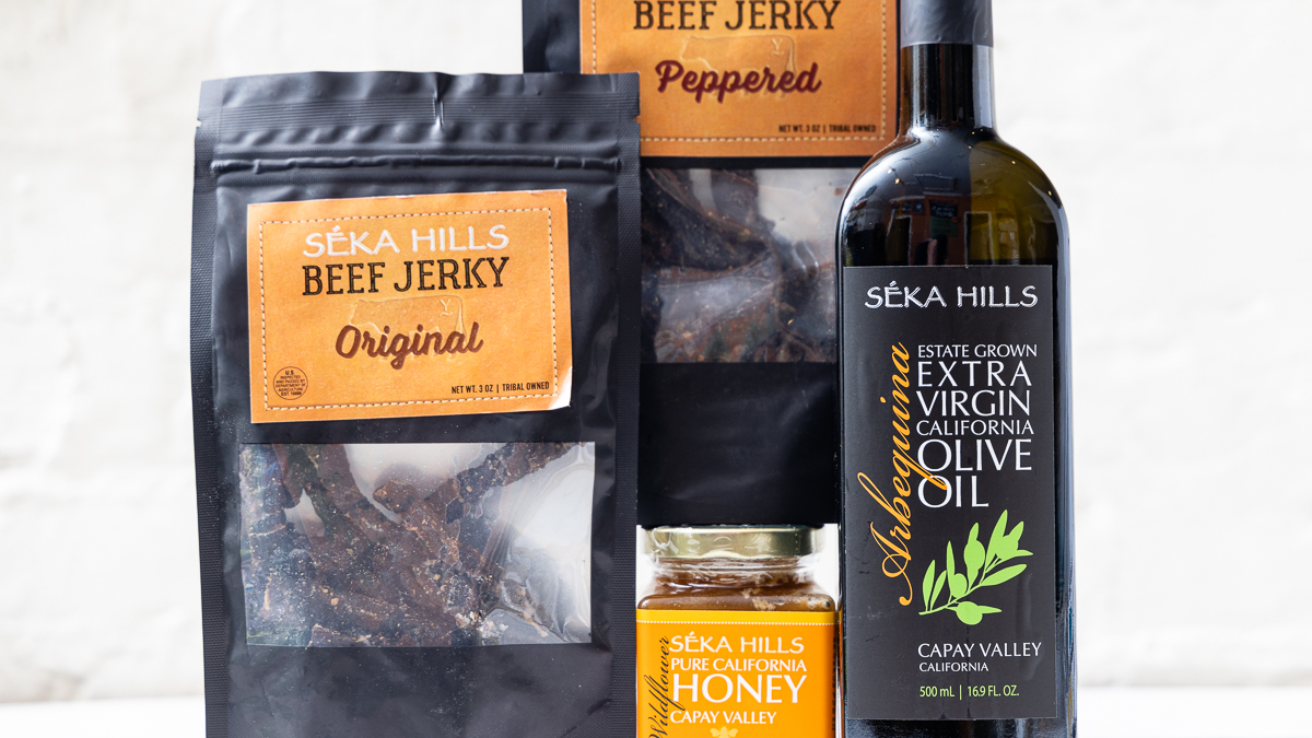 a photo of 4 products from Seka Hills: an olive oil, a jar of honey and 2 packages of beef jerkey