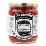 Making Sauerkraut Salad for Supper A jar of The Brinery Galaxy Rose Sauerkraut. The jar is wide and cylindrical with a gold lid and a black and white label. The sauerkraut inside is pink.