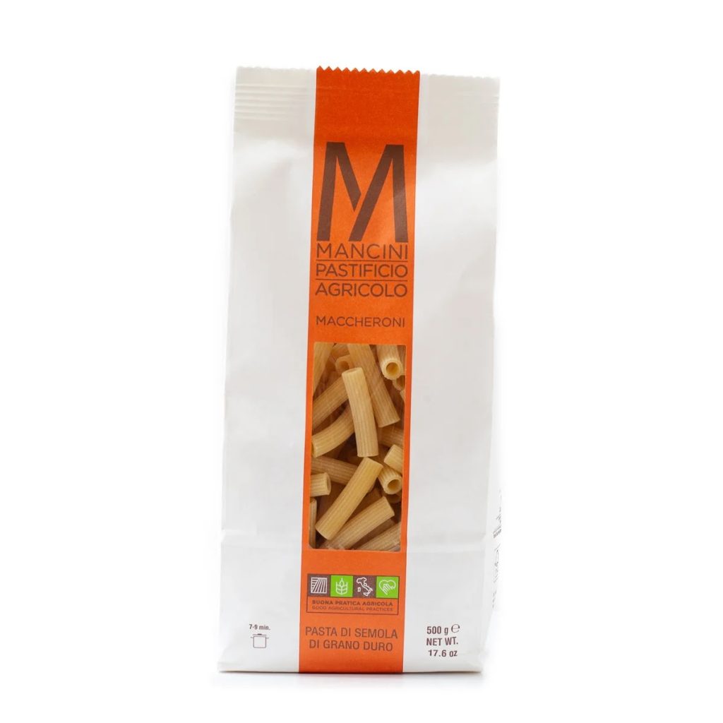 A photo of a bag of Mancini Maccheroni pasta. The bag is white with an orange stripe down the center.