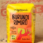 August Roaster’s Pick: Burundi Rimiro Natural Coffee A photo of a bag of Burundi Rimiro beans against a burlap coffee sack background.