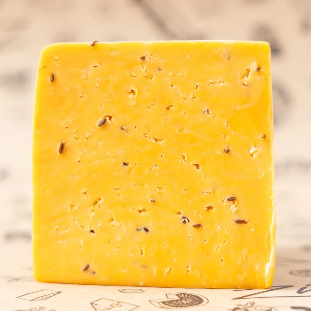 A photo of a square wedge of Carawaybou cheese. 