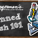 Tinned Fish 101 A graphic featuring a chalkboard background and an illustration of a tin of fish sitting at a desk with a giant pencil, and the Deli logo off to the side with text below that reads "Tinned Fish 101."