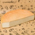 Treizième Apôtre: Terrific Raw Milk Farmstead Cheese A photo of half a wheel of Trezième Apôtre on a sheet of brown butcher paper.