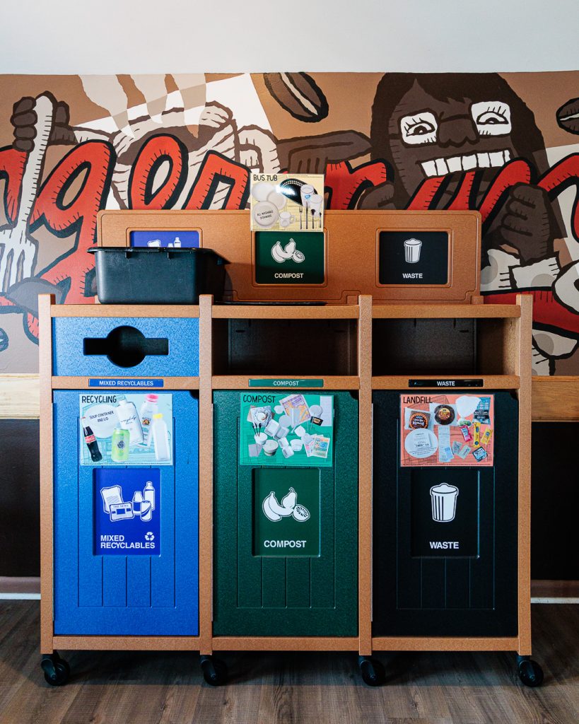 A photo of a set of waste stream sorting bins inside the Next Door Cafe.