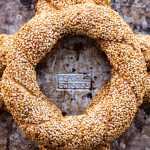 Make a Simit Sandwich at Home! A top-down photo of five rings of Simit on a metal baking tray.